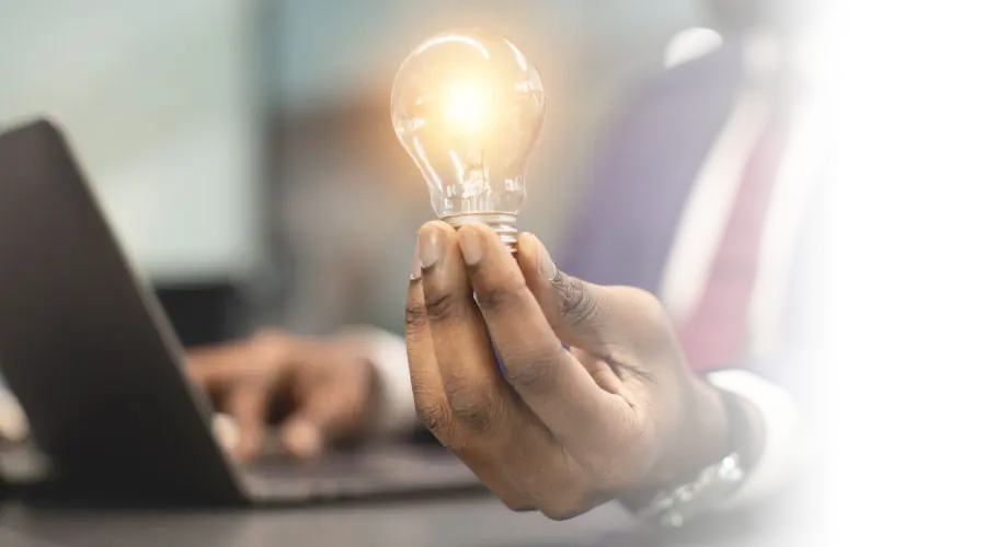 Hand holding a glowing light bulb